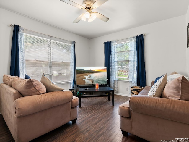 living area with dark wood-style floors, baseboards, and a ceiling fan