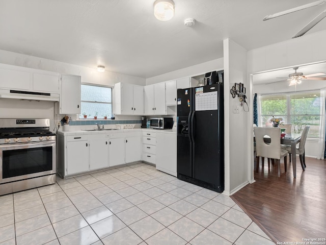 kitchen with white cabinets, light countertops, a ceiling fan, under cabinet range hood, and stainless steel appliances