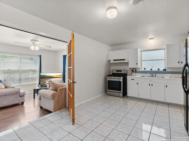 kitchen with a sink, stainless steel gas range, white cabinetry, and under cabinet range hood