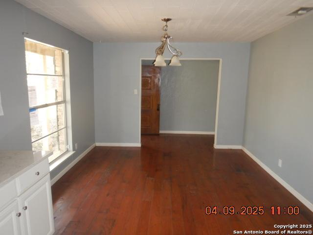 9704 Big Geronimo, San Antonio, TX 78254 - unfurnished dining area featuring dark wood-type flooring, visible vents, baseboards, and plenty of natural light