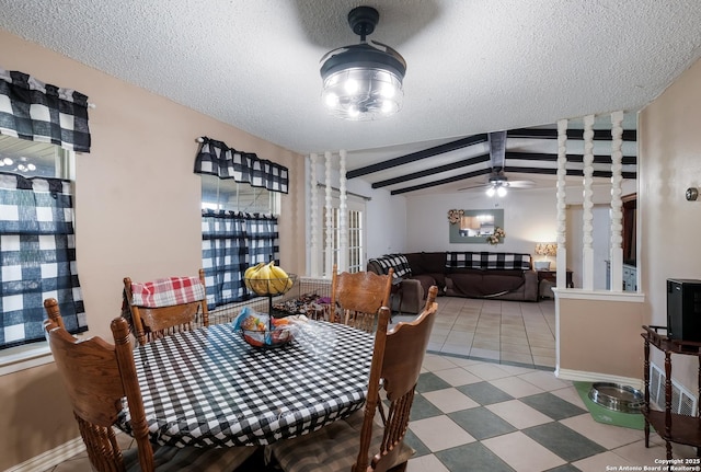 dining room with a ceiling fan, baseboards, vaulted ceiling with beams, and a textured ceiling