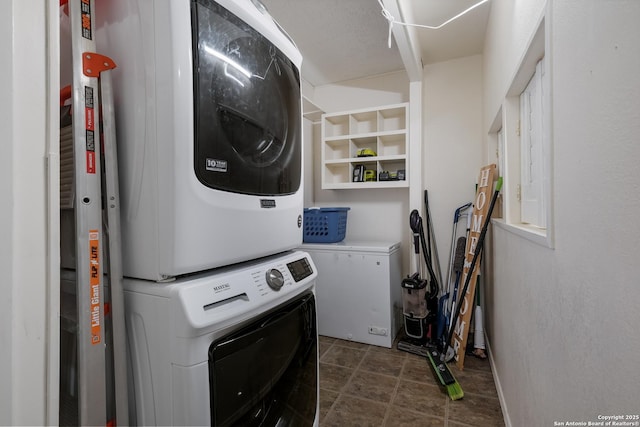 laundry room featuring stacked washer / dryer and laundry area