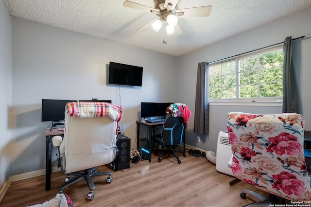 office featuring a textured ceiling, wood finished floors, baseboards, and a ceiling fan