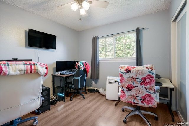 office area featuring ceiling fan, baseboards, wood finished floors, and a textured ceiling
