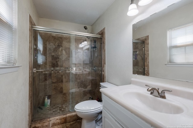 bathroom with vanity, a stall shower, and toilet
