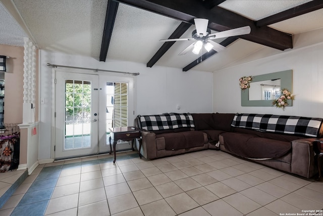 living area with a textured ceiling, vaulted ceiling with beams, a ceiling fan, and light tile patterned flooring