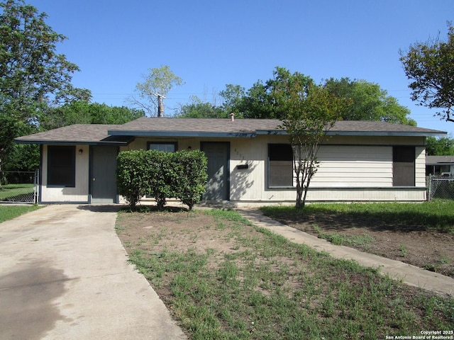 single story home with fence, a shingled roof, and driveway