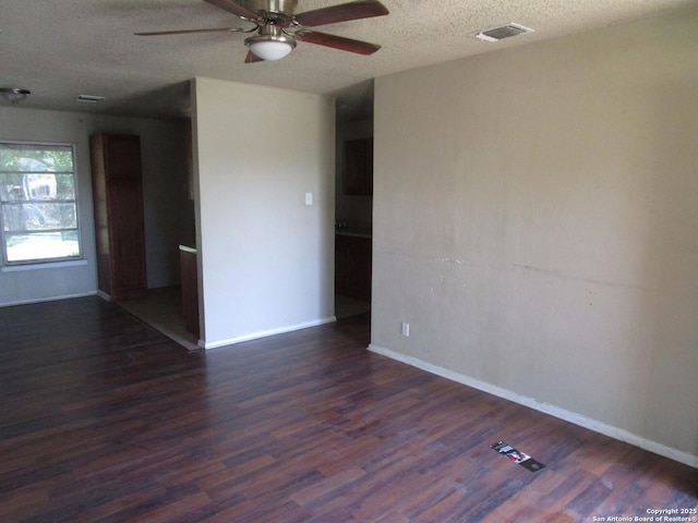 spare room featuring a textured ceiling, wood finished floors, ceiling fan, and visible vents