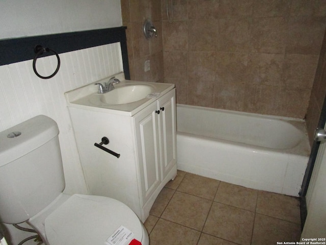 bathroom featuring toilet, tile patterned floors, vanity, and washtub / shower combination