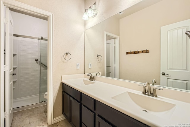805 Raceland, San Antonio, TX 78245 - bathroom featuring a shower stall, double vanity, a sink, and toilet