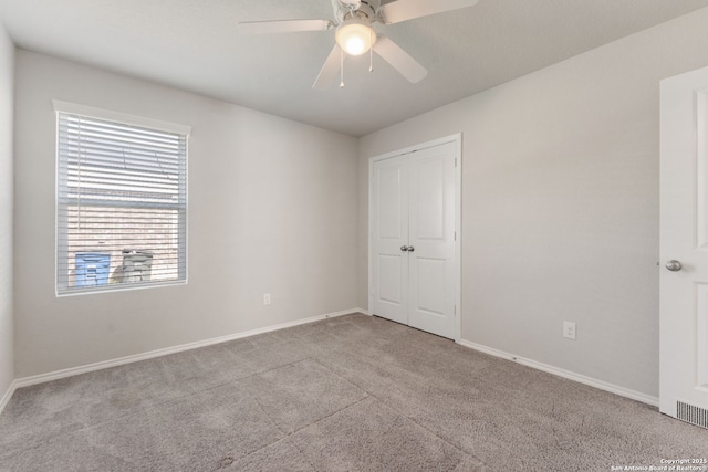 unfurnished bedroom featuring a closet, baseboards, a ceiling fan, and carpet