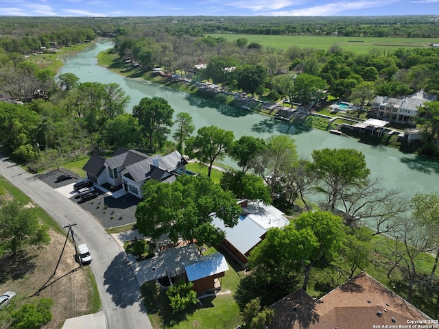 aerial view featuring a wooded view and a water view