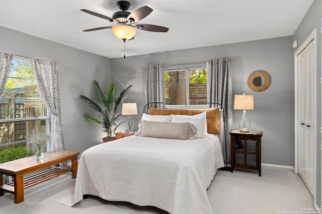 carpeted bedroom with a ceiling fan, baseboards, and a closet