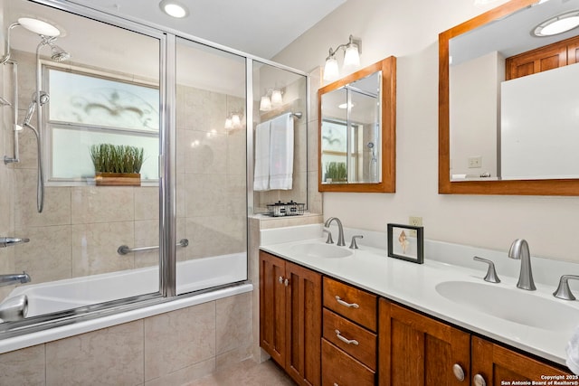 bathroom with tiled shower / bath, double vanity, tile patterned flooring, and a sink