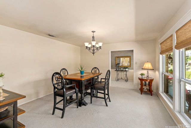dining space with baseboards, visible vents, a notable chandelier, and light colored carpet