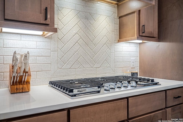 kitchen with tasteful backsplash, light countertops, and stainless steel gas cooktop