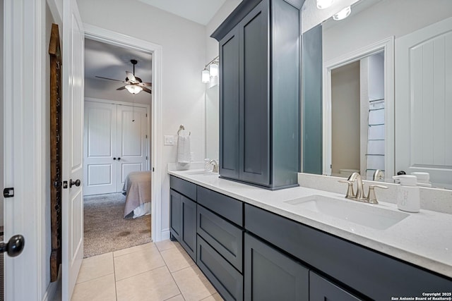 ensuite bathroom with tile patterned flooring, double vanity, a sink, and ceiling fan