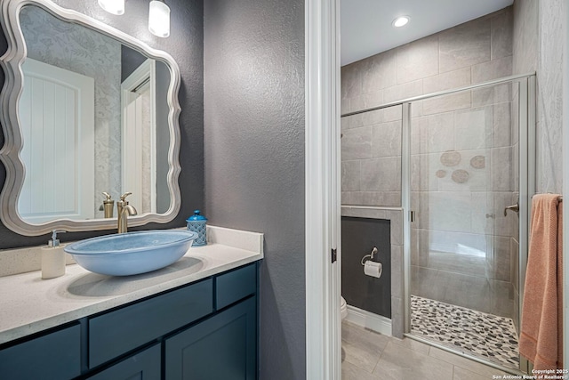 bathroom with toilet, tile patterned flooring, a stall shower, and a textured wall