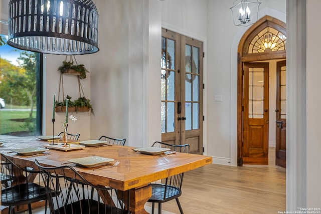 dining room featuring french doors, baseboards, a chandelier, and wood finished floors
