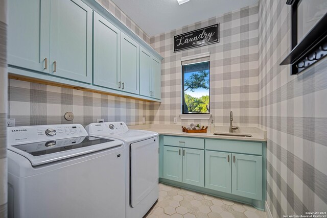 washroom featuring wallpapered walls, light tile patterned flooring, cabinet space, washer and dryer, and a sink