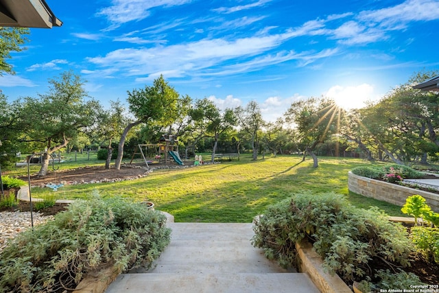 surrounding community featuring playground community, fence, and a lawn