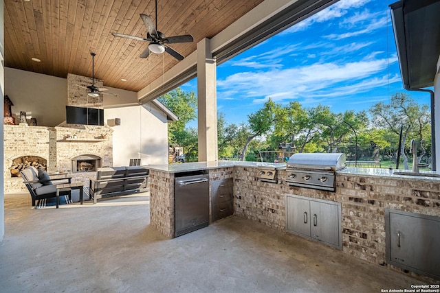 view of patio / terrace featuring grilling area, ceiling fan, exterior kitchen, and a fireplace