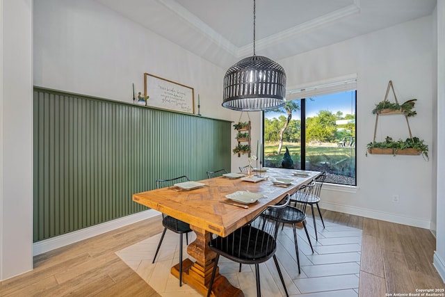 dining space with wood finished floors, baseboards, and ornamental molding