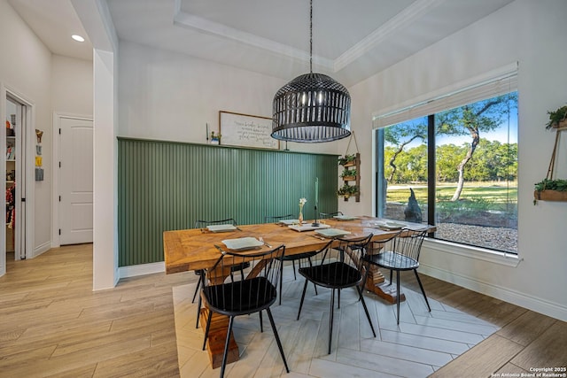 dining space featuring crown molding, a tray ceiling, recessed lighting, light wood finished floors, and baseboards