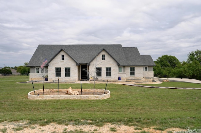 view of front of property featuring a shingled roof, stone siding, and a front lawn