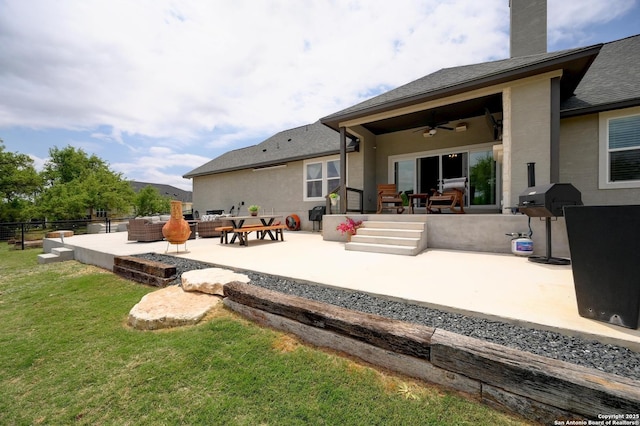 back of property featuring a patio, outdoor lounge area, stucco siding, ceiling fan, and a lawn