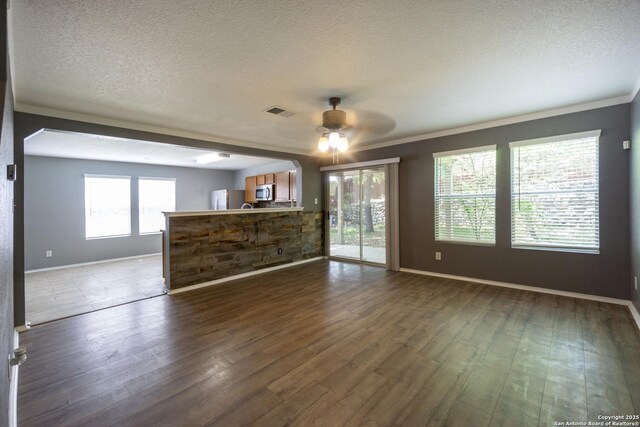16427 Kentucky, Selma, TX 78154 - unfurnished living room with a textured ceiling, a ceiling fan, visible vents, dark wood-style flooring, and baseboards