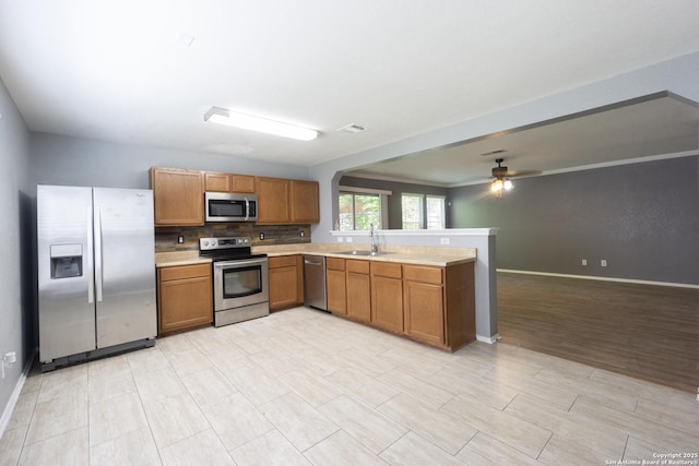 16427 Kentucky, Selma, TX 78154 - kitchen with a sink, light countertops, a peninsula, brown cabinets, and stainless steel appliances