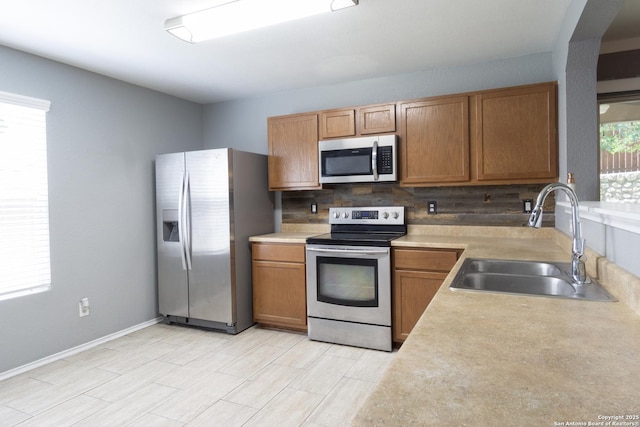 16427 Kentucky, Selma, TX 78154 - kitchen with appliances with stainless steel finishes, light countertops, brown cabinetry, decorative backsplash, and a sink