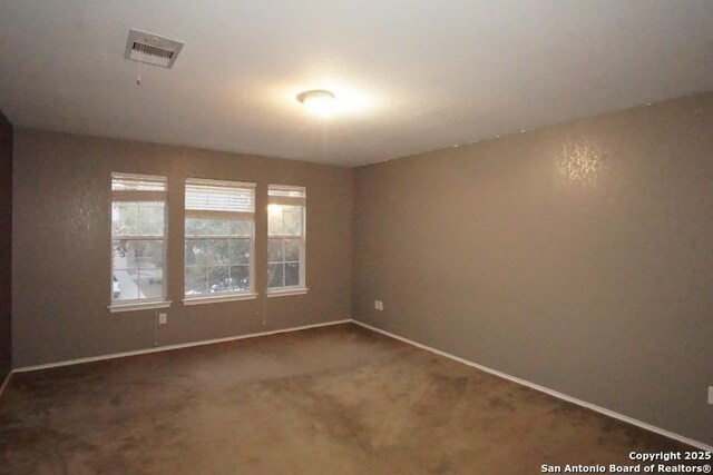 unfurnished room with visible vents, baseboards, and carpet floors