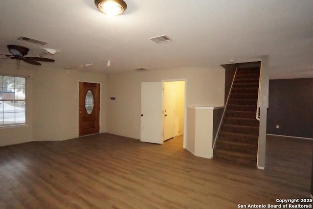 interior space featuring wood finished floors, ceiling fan, visible vents, and stairway