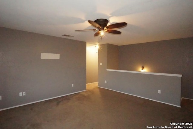 carpeted spare room featuring ceiling fan, baseboards, and visible vents