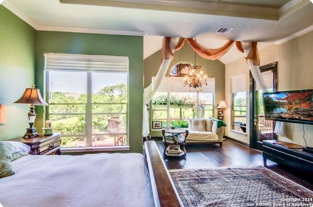 bedroom with multiple windows, a notable chandelier, wood finished floors, and visible vents
