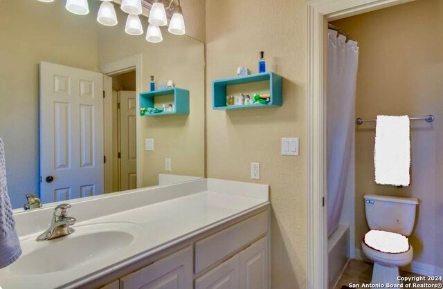 full bathroom with vanity, toilet, and an inviting chandelier
