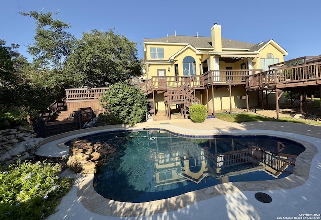 pool featuring fence, stairs, a patio area, and a deck