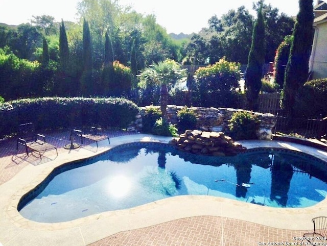 view of swimming pool featuring fence, a fenced in pool, and a patio area