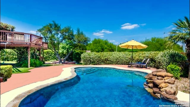 pool with a patio area and a deck