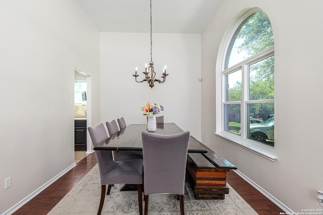 dining room with an inviting chandelier, dark wood-style floors, and baseboards