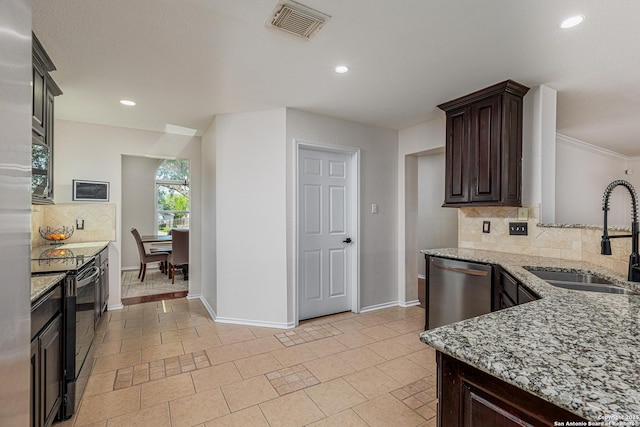 kitchen featuring a sink, decorative backsplash, black electric range, baseboards, and visible vents