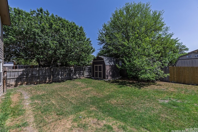 view of yard featuring a fenced backyard, an outdoor structure, and a storage shed