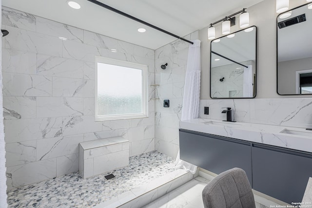 bathroom featuring visible vents, recessed lighting, vanity, and a tile shower