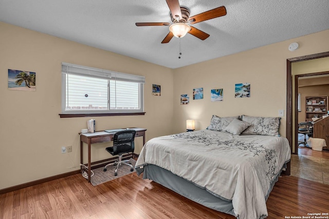 5906 Kissing Oak, San Antonio, TX 78247 - bedroom featuring baseboards, a ceiling fan, wood finished floors, and a textured ceiling