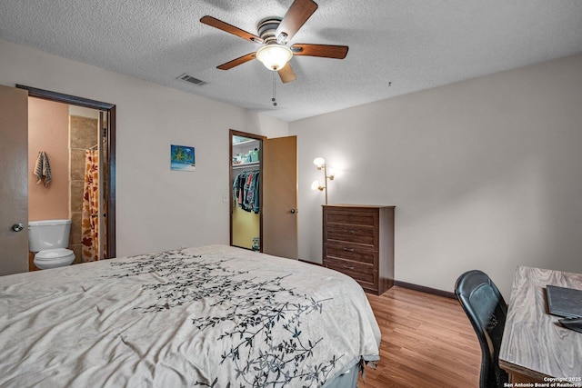 5906 Kissing Oak, San Antonio, TX 78247 - bedroom with wood finished floors, visible vents, a ceiling fan, ensuite bath, and a textured ceiling