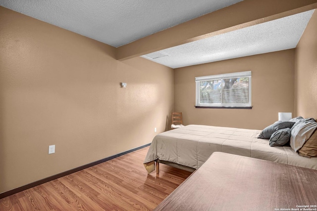 5906 Kissing Oak, San Antonio, TX 78247 - bedroom featuring light wood-style flooring, a textured ceiling, baseboards, and beam ceiling