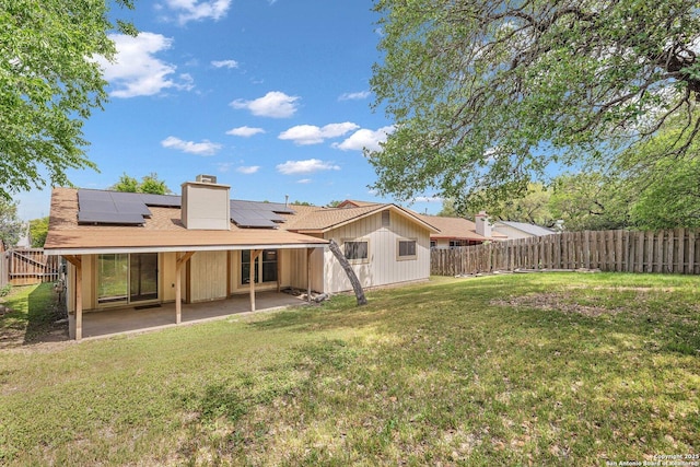 5906 Kissing Oak, San Antonio, TX 78247 - back of property featuring a fenced backyard, solar panels, a chimney, a lawn, and a patio
