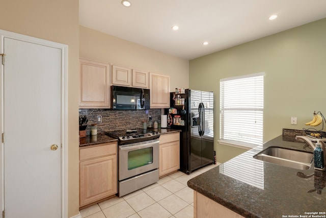 kitchen featuring light brown cabinetry, a sink, light tile patterned flooring, backsplash, and black appliances